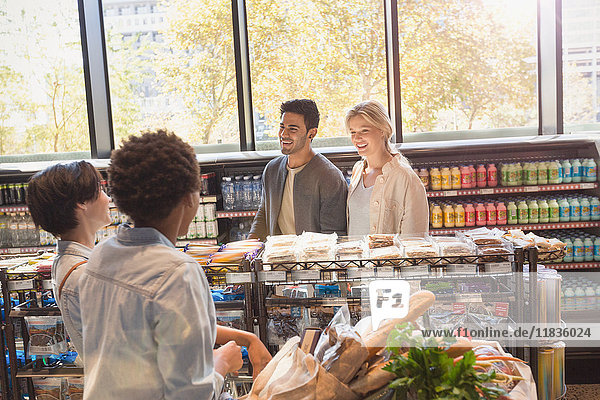 Young friends talking in grocery store market