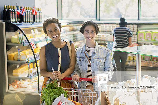 Portrait smiling young lesbian couple  grocery shopping in market