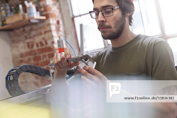 Male designer using calipers in workshop