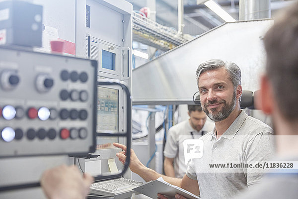 Portrait lächelnder Manager am Maschinenleitstand in der Fabrik