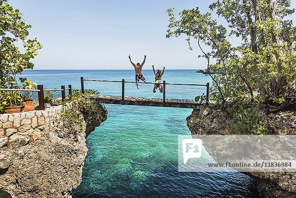 Jamaica  Negril  People jumping into ocean from footbridge