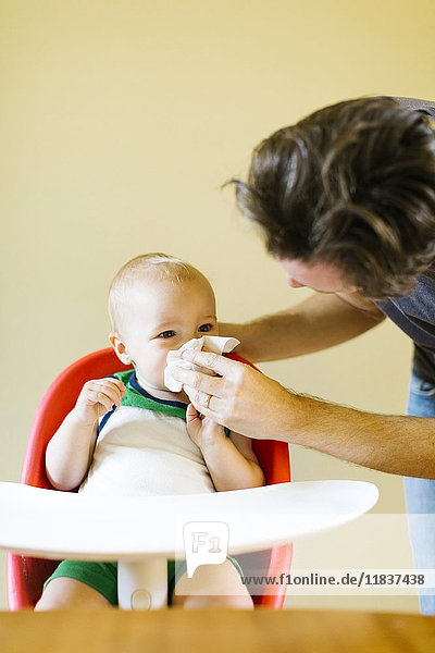 Vater hilft seinem Sohn (12-17 Monate) beim Naseputzen