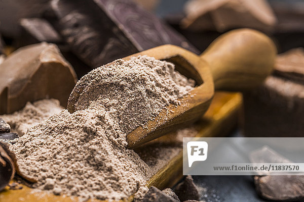 Still life with wooden scoop full with chocolate powder