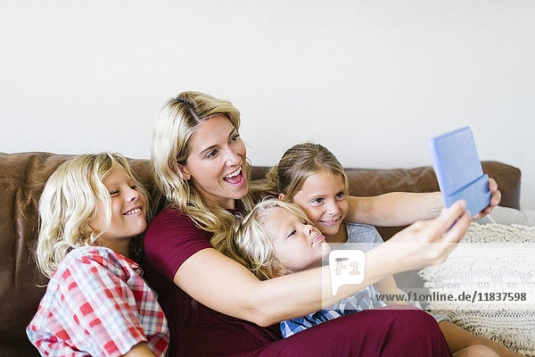 Mutter und Kinder (4-5  6-7  8-9) machen ein Selfie mit einem digitalen Tablet