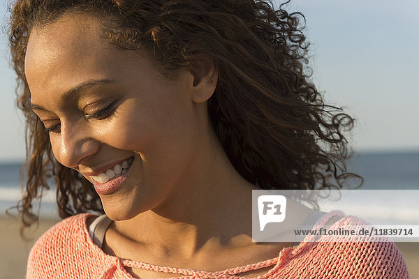 Porträt einer lächelnden afroamerikanischen Frau am Strand