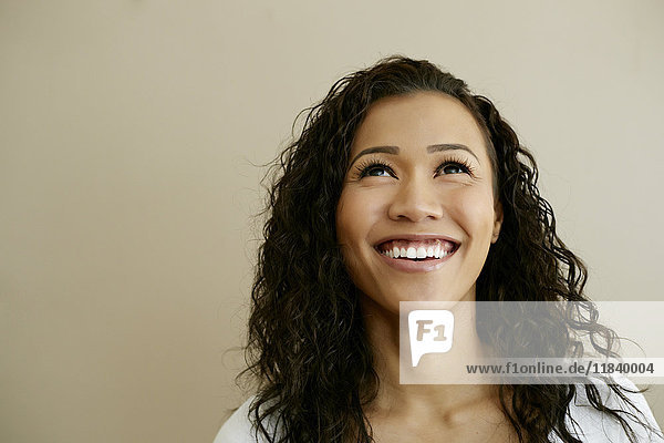 Porträt einer lächelnden gemischtrassigen Frau  die nach oben schaut