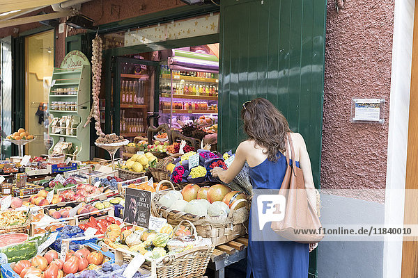 Caucasian woman shopping for fruit at sidewalk market