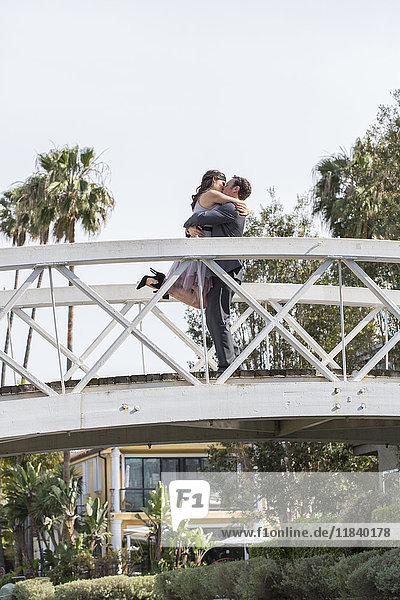Küssendes Paar beim Feiern auf der Brücke