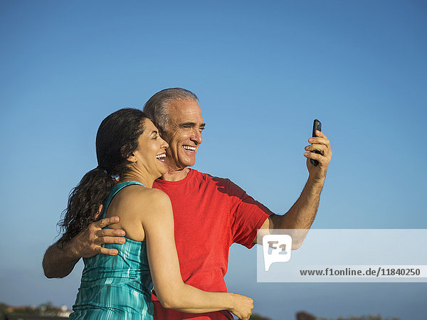 Älteres Paar lachend und posierend für Handy-Selfie
