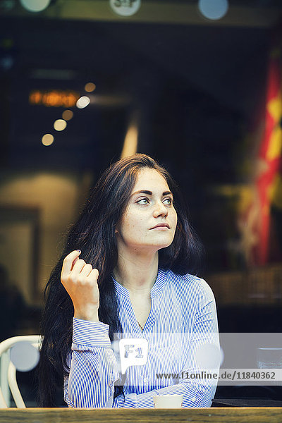 Pensive Caucasian woman drinking coffee at cafe