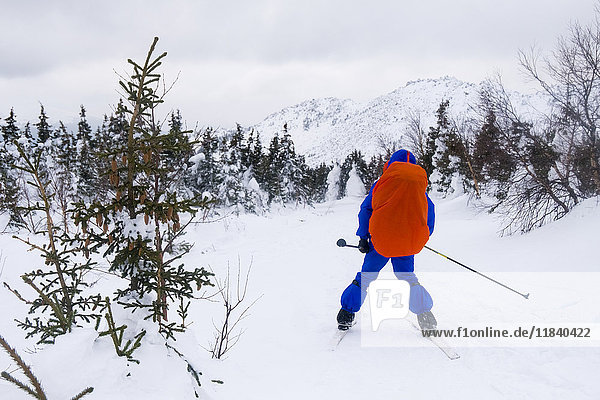 Kaukasischer Mann beim Skilanglauf in der Nähe eines Berges