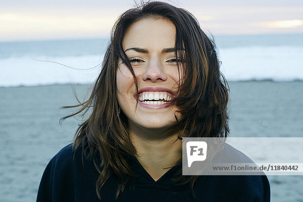 Porträt einer lachenden kaukasischen Frau am Strand