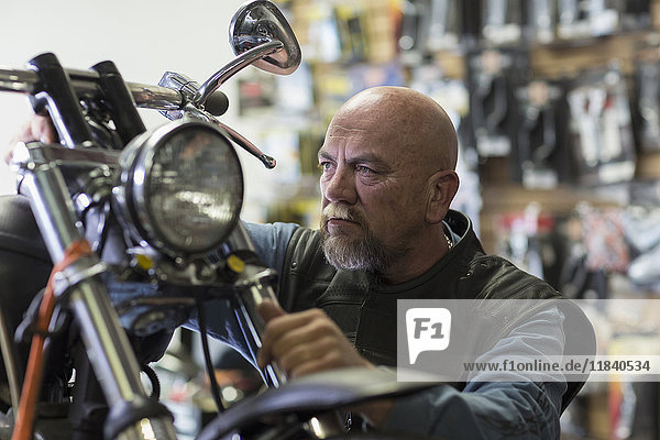 Kaukasischer Mann repariert Motorrad