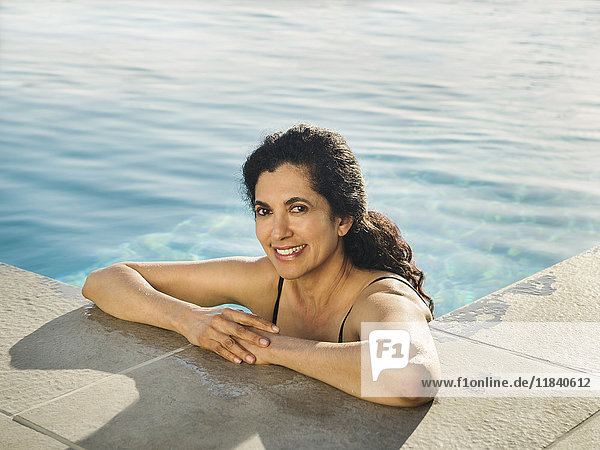 Porträt einer hispanischen Frau  die sich im Schwimmbad entspannt