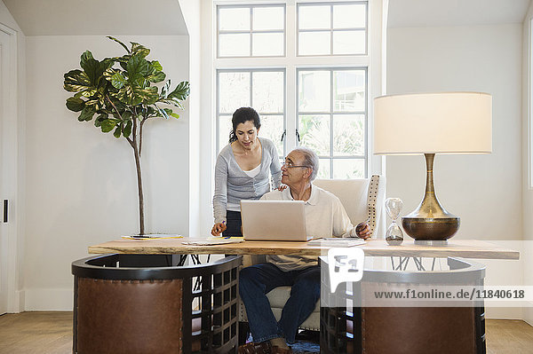 Older couple using laptop in home office