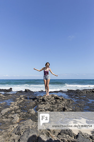 Mixed Race Frau stehend auf Felsen am Strand