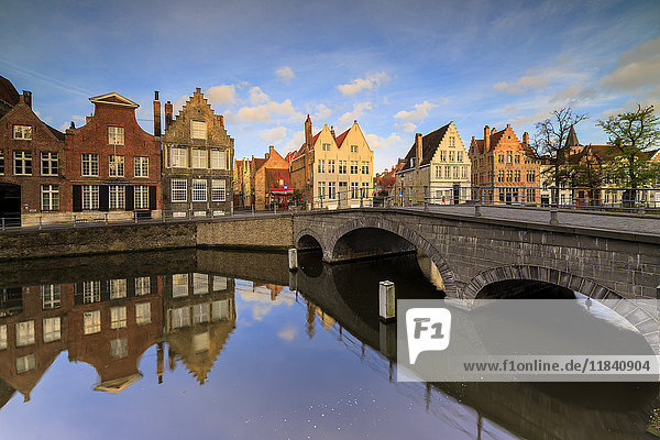 First light of sunrise on the historic buildings and bridge reflected in the typical canal  Bruges  West Flanders  Belgium  Europe