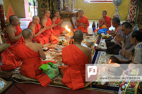 Buddhist monks praying  Sai Sin  the cotton thread symbolizing the sacred bond  Wat Simuong (Wat Si Muang)  Vientiane  Laos  Indochina  Southeast Asia  Asia