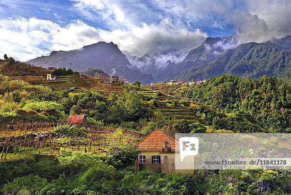 Erhöhter Blick auf ein Dorf und baumbewachsene Hügel und Berge bei Lameiros  in der Nähe von Sao Vicente  Madeira  Portugal  Atlantik  Europa