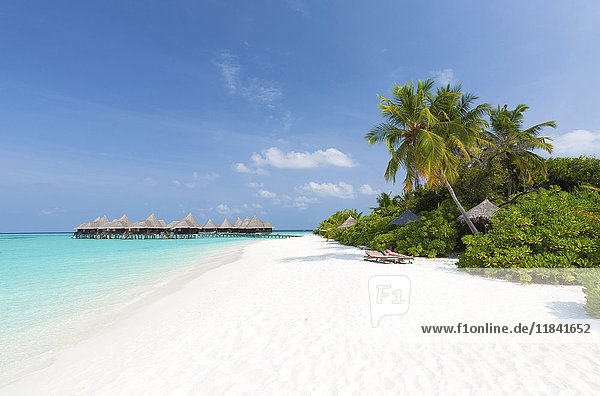 View along tropical beach towards over-water villas Coco Palm Resort Dhuni Kolhu Baa Atoll Republic of Maldives Indian Ocean Asia