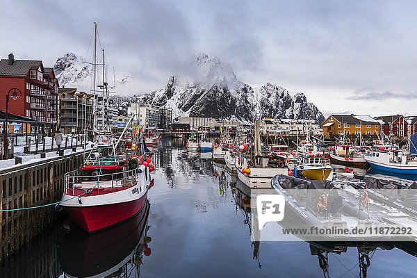 Boote in einem Hafen mit zerklüfteten Bergen entlang der Küstenlinie; Svolvar  Lofoten  Nordland  Norwa'.