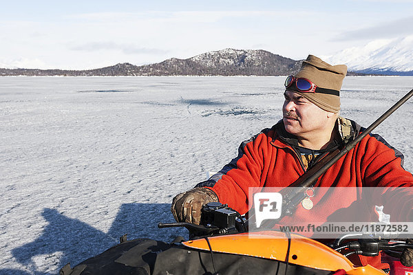 Hunter on an ATV during a freshwater harbor seal hunt  Lake Iliamna  Pedro Bay  Southcentral Alaska  USA