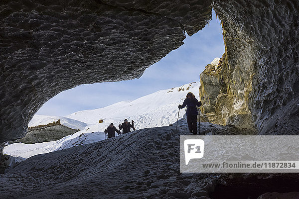 Wanderer betreten eine Eishöhle im Castner-Gletscher in der Alaska Range.