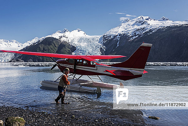 Pilot manövriert ein Cessna 206 Wasserflugzeug; Coxe Glacier im Barry Arm des Prince William Sound; Süd-Zentral-Alaska; Gezeitengletscher'.