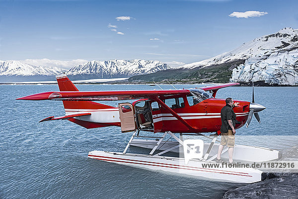 Mann steht auf dem Schwimmer einer Cessna 206  Lake George  Colony Glacier  Süd-Zentral-Alaska  USA