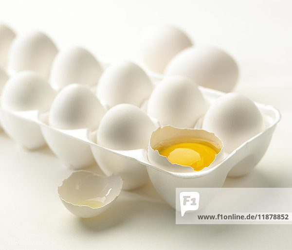 Weiße Eier in einem Styropor-Karton auf weißem Hintergrund