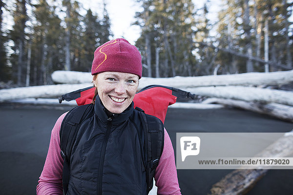 Eine Frau steht am Strand und trägt einen Rucksack  Kenai-Halbinsel  Außenküste; Alaska  Vereinigte Staaten von Amerika'.