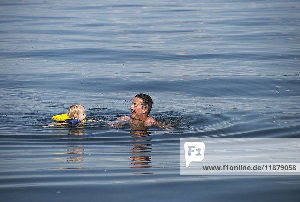 Ein junges kaukasisches Mädchen schwimmt mit ihrem Vater im Seneca-See  Upstate New York; Dresden  New York  Vereinigte Staaten von Amerika