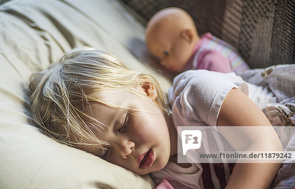 Ein kaukasisches Kleinkind mit blondem Haar schläft mit seiner Puppe; Penn Yan  New York  Vereinigte Staaten von Amerika'.