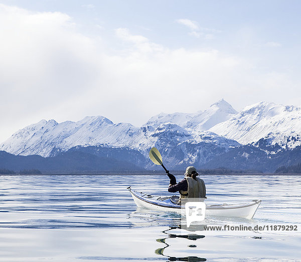 Paddeln im Kanu auf ruhigem Wasser mit Blick auf die schneebedeckten Kenai Mountains  Kachemak Bay State Park; Alaska  Vereinigte Staaten von Amerika'.