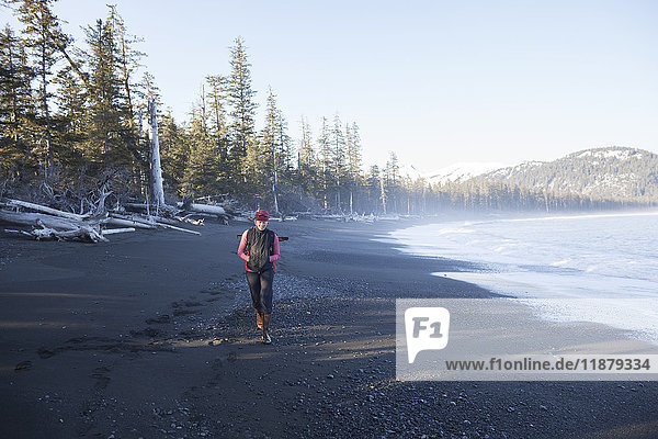 'A woman walking on the beach  Kenai Peninsula outer coast; Alaska  United States of America'