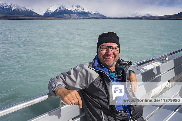 Ein Tourist sitzt auf einem Boot und posiert für ein Foto auf einer Kreuzfahrt auf dem Lago Argentino in der Nähe von El Calafate  argentinisches Patagonien; El Calafate  Provinz Santa Cruz  Argentinien'.