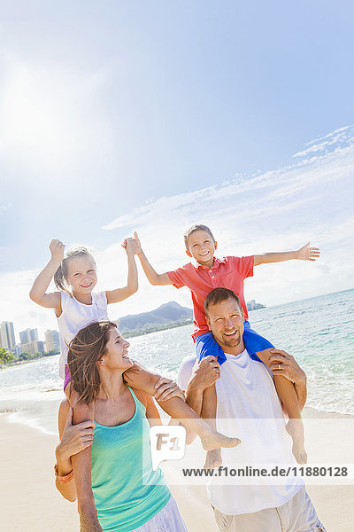 Vierköpfige Familie genießt einen Sommerurlaub auf Hawaii am Waikiki Beach; Oahu  Hawaii  Vereinigte Staaten von Amerika'.
