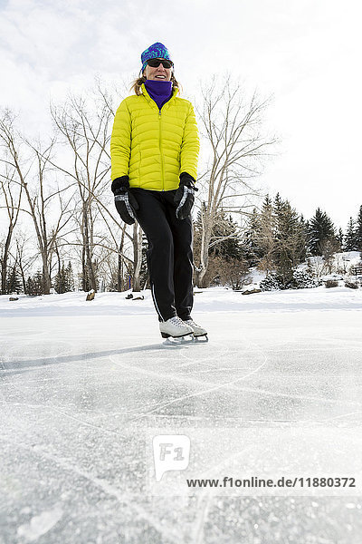 'Low angle view of a woman skating on a frozen pond; Calgary  Alberta  Canada'