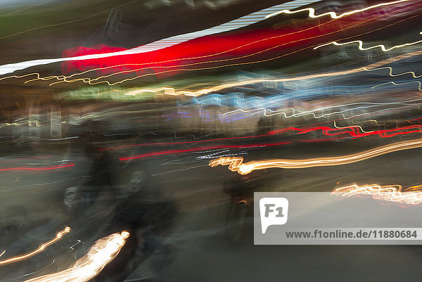 Langzeitbelichtung von Lichtspuren in verschiedenen Farben und ein schwacher Blick auf ein Motorrad auf der Straße; Chiang Rai  Thailand'.