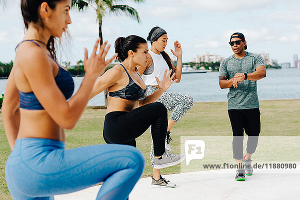 Drei Frauen trainieren mit einem persönlichen Trainer  South Point Park  Miami Beach  Florida  USA