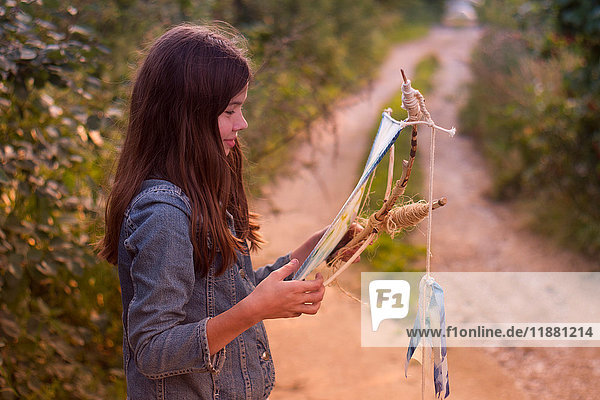 Teenage girl gazing at kite on dirt track