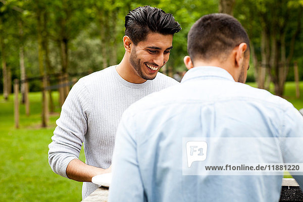 Man having barbecue in park with friend