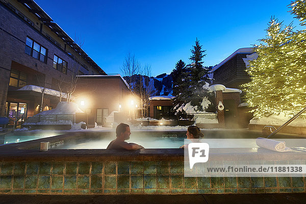 Reifes Paar entspannt sich in der Abenddämmerung im Whirlpool eines Hotels im Freien  Aspen  Colorado  USA