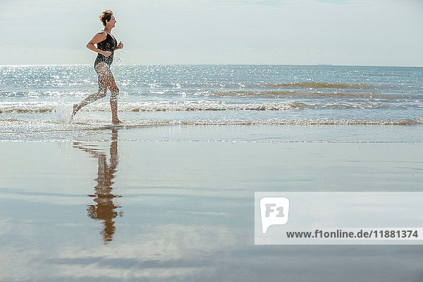 Frau läuft am Strand  Folkestone  UK
