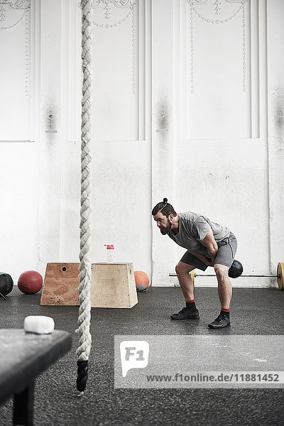 Man working out with kettlebell in cross training gym