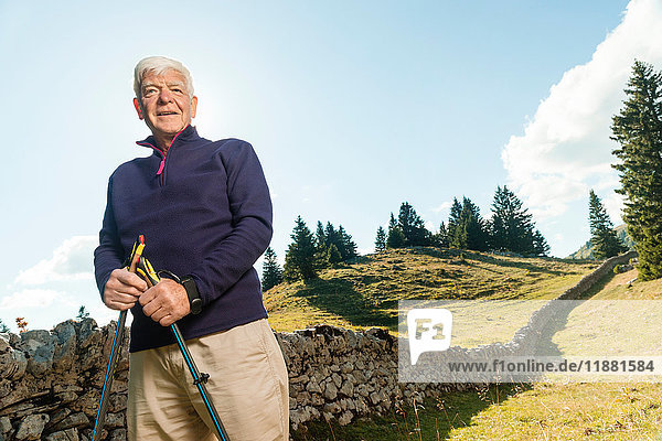 Portrait of senior man in rural setting  holding walking poles  Geneva  Switzerland  Europe