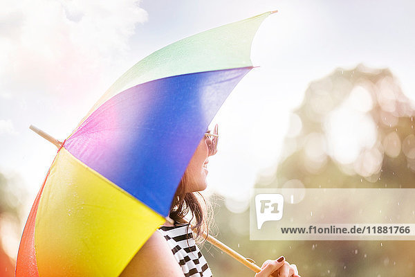 Porträt einer Frau mit Regenschirm beim Wegschauen