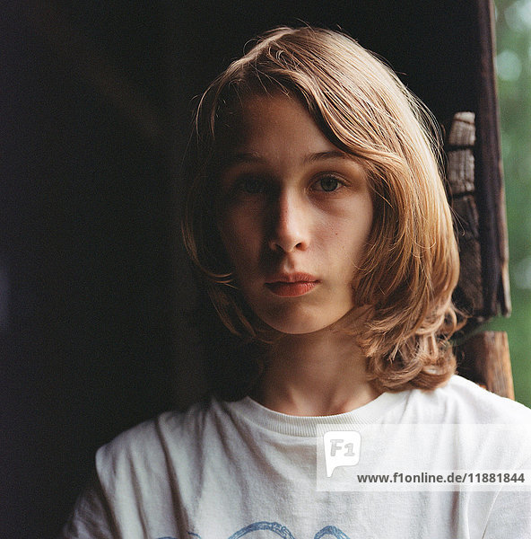 Portrait of boy with long hair  pensive expression