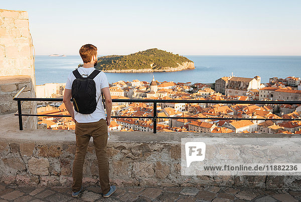 Rear view of man looking away at sea over rooftops  Dubrovnik  Dubrovacko-Neretvanska  Croatia  Europe
