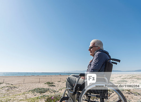 Älterer Mann im Rollstuhl mit Blick aus den Dünen  Playa del Ray  Kalifornien  USA